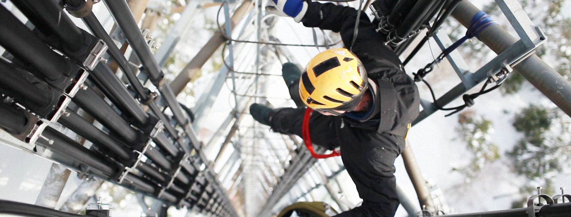 A man in a helmet climbing up a ladder, demonstrating determination and focus in his ascent.